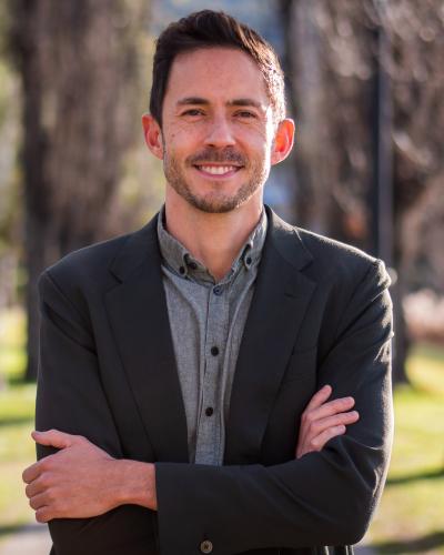 Dr Jason Chin standing outside, smiling with his arms crossed wearing a light grey shirt and dark grey blazer.